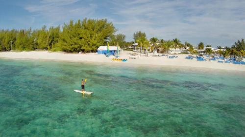 a person on a surfboard in the water near a beach at Viva Fortuna Beach by Wyndham, A Trademark All Inclusive in Freeport