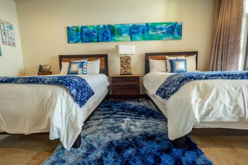 a bedroom with two beds and a blue rug at Expectacular Penthouse frente al Mar con Jacuzzi in Jacó