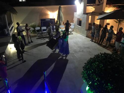a group of people standing on a patio at night at Appartement Touta écologique familial in Ḩawmat al Badawīyīn