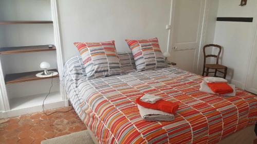 a bedroom with a bed with pillows and a chair at La Fruitiere in Saints