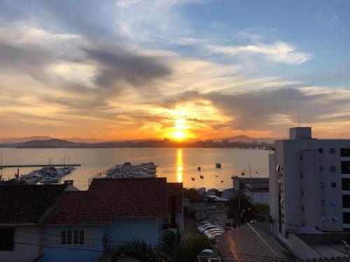 um pôr do sol sobre um porto com barcos na água em Hostel Berghaus em Florianópolis
