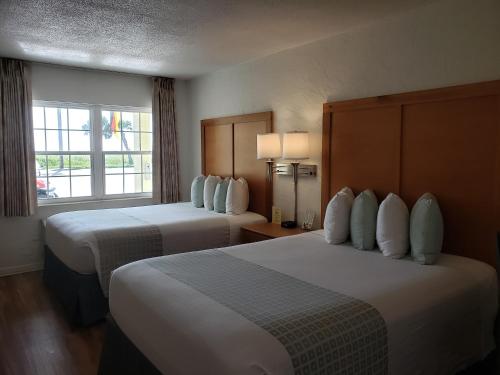 a hotel room with two beds and a window at Studio 1 Motel - Daytona Beach in Daytona Beach
