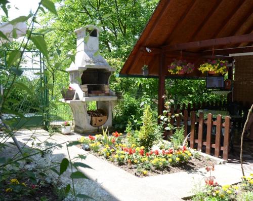 a garden with a stone fountain and some flowers at Guesthouse Vila Natalija in Gornja Trepča