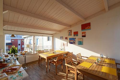 ein Esszimmer mit Tischen und Stühlen und einem großen Fenster in der Unterkunft Miramed rooms in Termoli