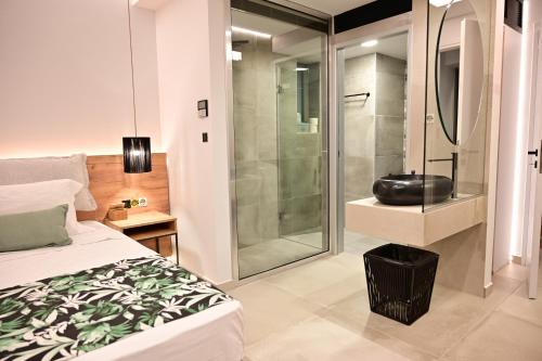 a bedroom with a shower and a bed and a bathroom at Kavos Hotel & Suites in Stavros