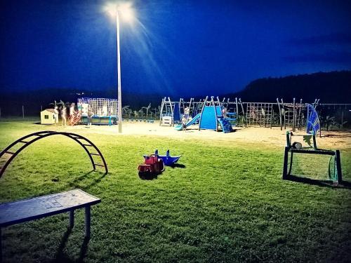 a park at night with a playground with a light at Makaza Complex in Momchilgrad