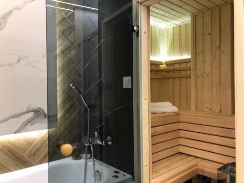 a bathroom with a tub and a shower with a sink at Family & Business Sauna Apartments Plac Wolności CENTRUM Downtow, UNIKAT - 6 Pokoi, 2 Łazienki, Parking, możliwość wyżywienia in Kielce