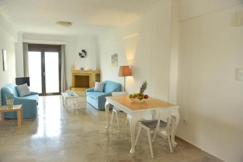 - un salon avec une table et un canapé bleu dans l'établissement NanSea Apartment, à Loutra Elenis
