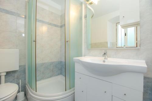 a bathroom with a sink and a shower and a toilet at Holiday HomeToni in Savar