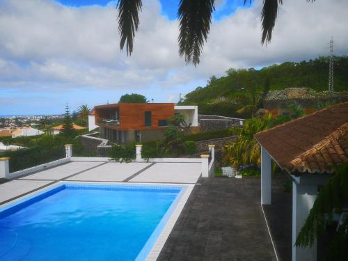 a swimming pool in front of a house at Quinta das Camélias - Açores in Ponta Delgada