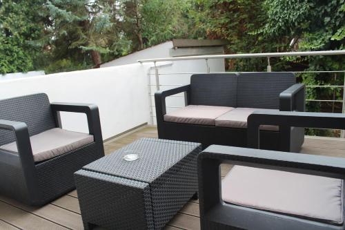 a patio with two chairs and a table on a deck at Singapore·CHILLINGHOUSE # 7, 3 Min.vom ICE,NETFLIX in Siegburg