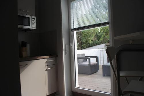 a kitchen with a window with a view of a deck at Singapore·CHILLINGHOUSE # 7, 3 Min.vom ICE,NETFLIX in Siegburg