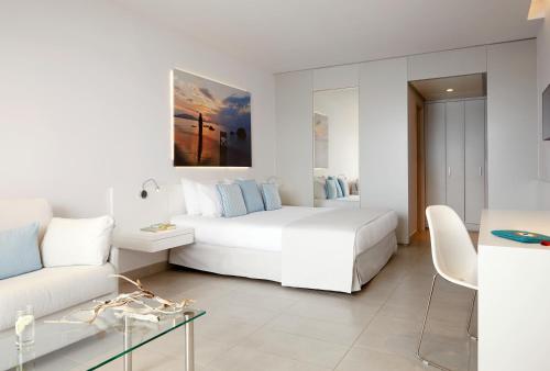a white bedroom with a bed and a couch at Lindos Mare, Seaside Hotel in Líndos