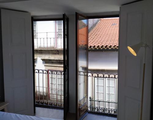 a room with two windows and a view of a building at Anjo33 Flats in Braga