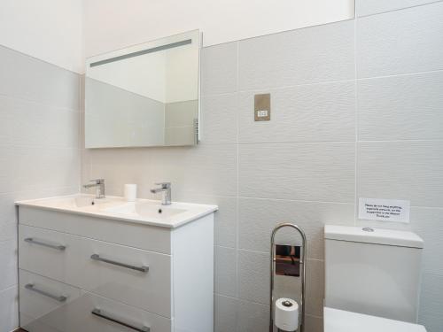 a bathroom with a sink and a toilet and a mirror at Gwel y Rhos in Llanfairpwllgwyngyll
