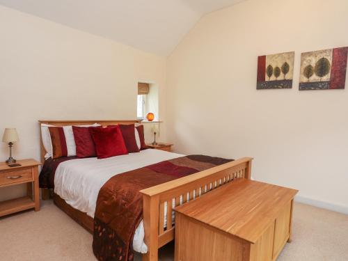a bedroom with a large bed with red pillows at Gwel y Rhos in Llanfairpwllgwyngyll