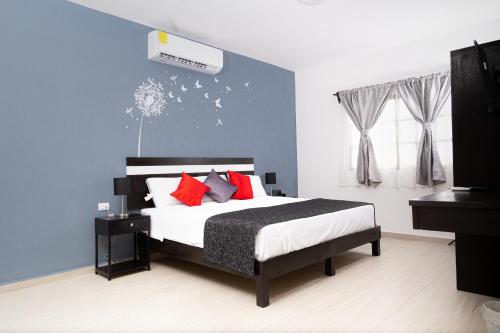 1 dormitorio con 1 cama grande con almohadas rojas en Santa Fe Studios And Suites, en Cancún