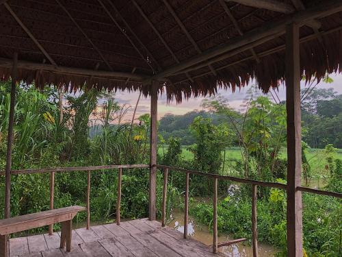 a porch with a bench and a view of a field at Iguana Lodge Perú in Iquitos