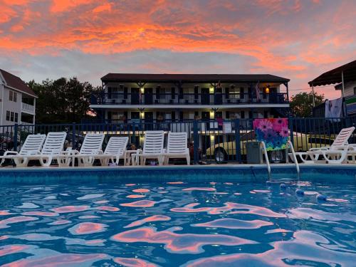 a pool with chairs and a house in the background at Island View Motel in Old Orchard Beach