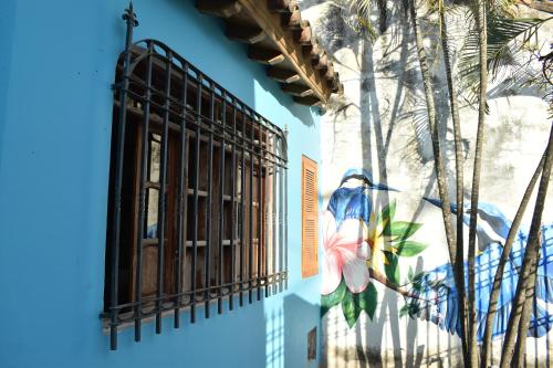a blue building with a window and a mural at Casa Isabelita in Mompos