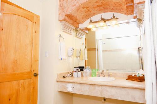 y baño con lavabo y espejo. en Business Hotel & Suites María Bonita, en Ciudad Juárez