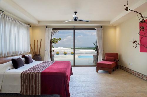 1 dormitorio con cama y vistas al océano en Fort Walker (Beachfront House+Studio) en Rivas