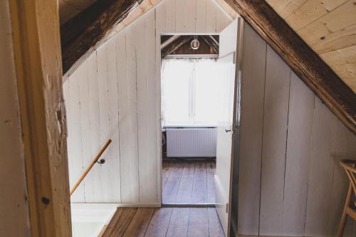 an attic hallway with a window and wooden floors at A pearl in the center of the center of Thorhavn in Tórshavn