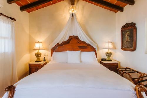 a bedroom with a large bed with a canopy at Hacienda San Angel in Puerto Vallarta