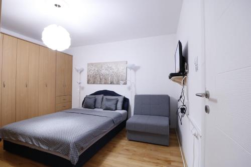 a bedroom with a bed and a chair at Iva City Center in Belgrade