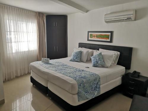 Un dormitorio con una cama grande en una habitación. en Hotel Santa Cecilia Cali, en Cali