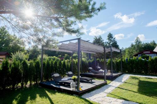 a garden with a gazebo and chairs in a yard at Boutique house Oreskovic in Plitvička Jezera
