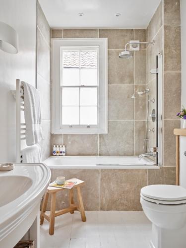 a bathroom with a tub and a toilet and a sink at Artisan Cottage - Historic cottage near to Bath, Lacock and Castle Coombe in Chippenham