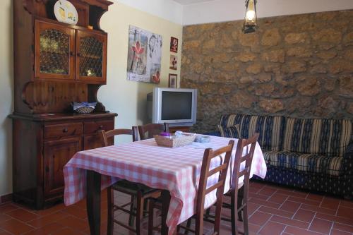 a dining room with a table with chairs and a tv at Agriturismo il Palagetto in Pomarance