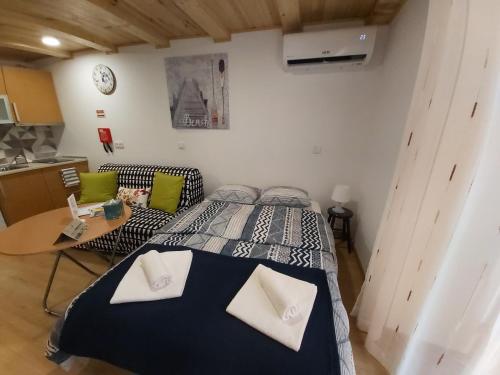 a bedroom with a bed and a table and a clock at Tipico Romantico I in Setúbal