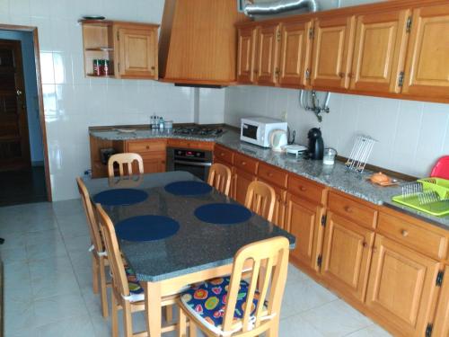 a kitchen with a table with chairs and a counter top at Apa Quinta de Fora in Viseu