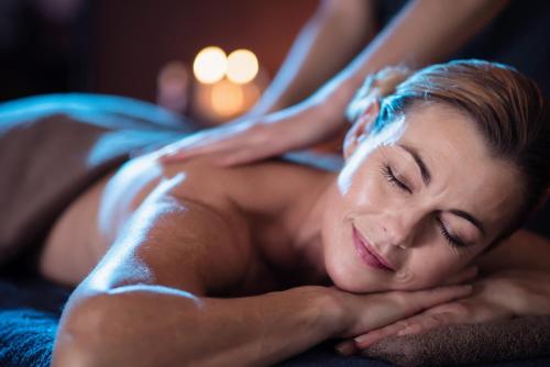 a woman getting a massage in a bed at Gibbston Valley Lodge and Spa in Queenstown