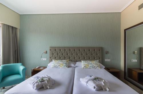 a bedroom with a bed with two towels on it at Hotel Bahía de Vigo in Vigo