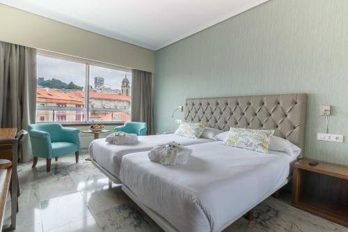 a bedroom with a large bed and a large window at Hotel Bahía de Vigo in Vigo