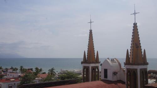 a church with two towers with the ocean in the background at Casa del Parque Vallarta in Puerto Vallarta