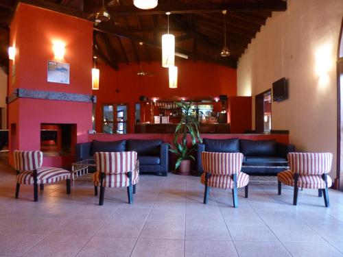 a lobby with a couch and chairs in a restaurant at Marcopolo Suites Iguazu in Puerto Iguazú