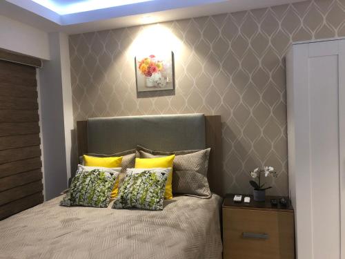 a bedroom with a bed with yellow pillows at Estancia Riviera Colonial I in Santo Domingo