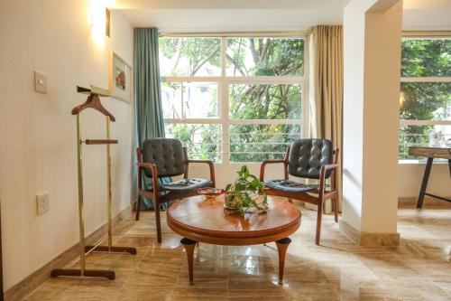 een woonkamer met 2 stoelen en een tafel bij Casa Comtesse in Mexico-Stad