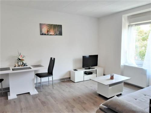 a living room with a couch and a desk and a tv at MyHome Basel RC44B in Saint-Louis