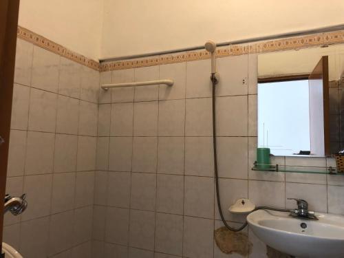 une salle de bain avec douche et lavabo dans l'établissement V A Motel, à Hai Phong