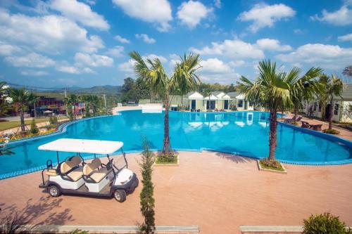 a golf cart parked in front of a swimming pool at Saichon Grand View in Ban Lam Rua Taek