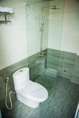 a bathroom with a toilet and a glass shower at Hue Four Seasons Hotel in Hue