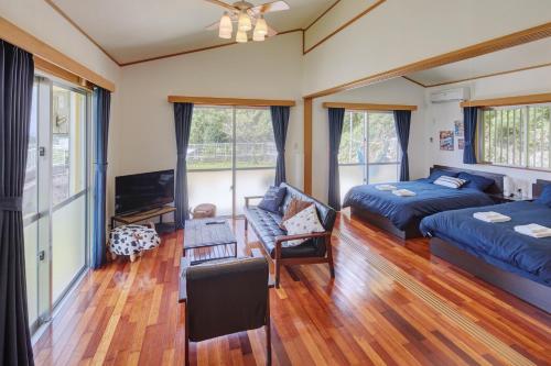 a living room with a bed and a couch at Casa de R in Motobu