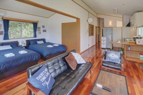 a living room with two beds and a couch at Casa de R in Motobu