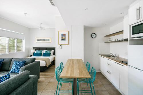 a living room with a couch and a table and a bed at Mantra PortSea in Port Douglas