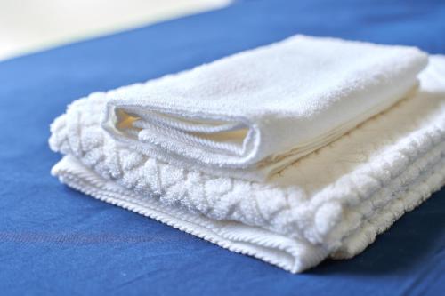 a stack of white towels sitting on a blue table at Casa de R in Motobu